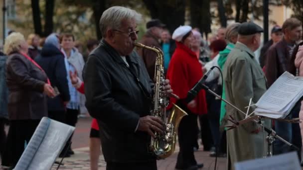 Chernihiv, Ucraina 22 spt 2019. Jucătorul saxofon sau muzicianul de sax cântă la petrecerea de dans a pensionarilor din parc — Videoclip de stoc