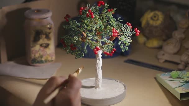 Female artist is painting the handmade wire tree before varnish process — Stock Video