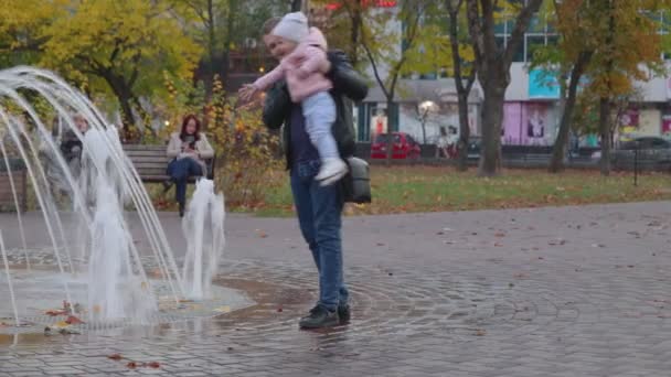 Chernihiv, Ucrânia. 13 out 2019. Jovem pai e seu filho estão brincando na fonte na praça da cidade — Vídeo de Stock