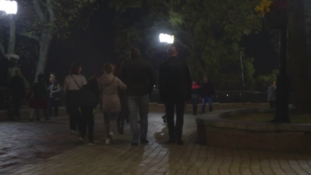 Chernihiv, Ucrania. 13 oct 2019. La gente está dando un paseo nocturno por el parque de otoño por la noche o tarde por la noche — Vídeos de Stock