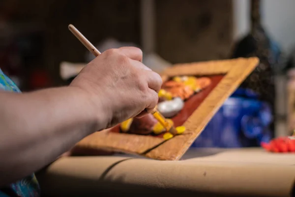 Cilalama işleminden önce kadın sanatçı el yapımı tabloyu temizliyor