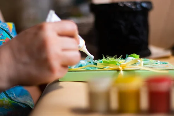 Kadın sanatçı el yapımı sanat eserlerinde yapıştırıcı kullanıyor.