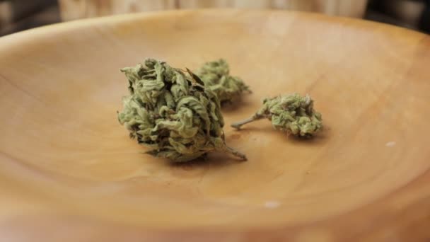 Sativa ve Indica ot tomurcukları dönen masanın üzerinde tahta tabakta. CBC, Thc illüstrasyon görüntüleri. Tam yakın plan. — Stok video