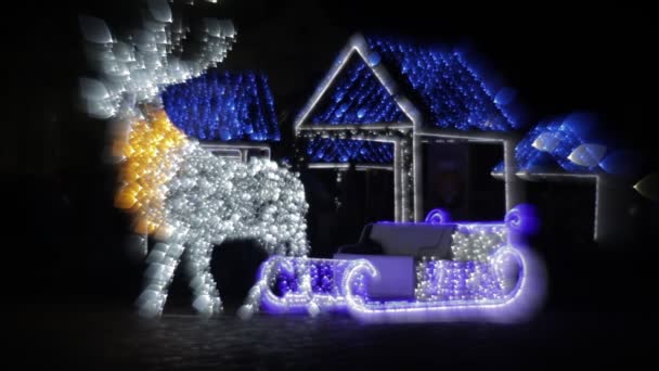 Lumières de renne de Noël rayonnantes Design avec de petites maisons sur fond. traîneau de Père Noël, décorations de Noël — Video