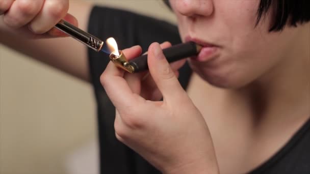 Jeune fille ou adolescent éclairage et pipe en laiton fumeur avec herbe de marijuana médicale à l'intérieur et expirer la fumée au ralenti — Video