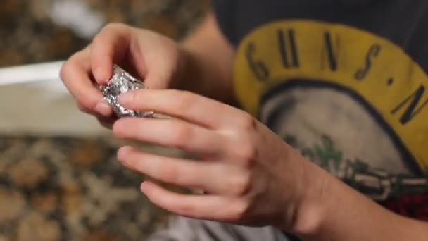 Young girl or teen unfolding the aluminum foil envelope with medical marijuana weed — 비디오