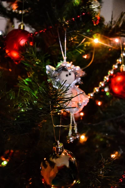 Brinquedos na árvore de Natal com luzes brilhantes — Fotografia de Stock