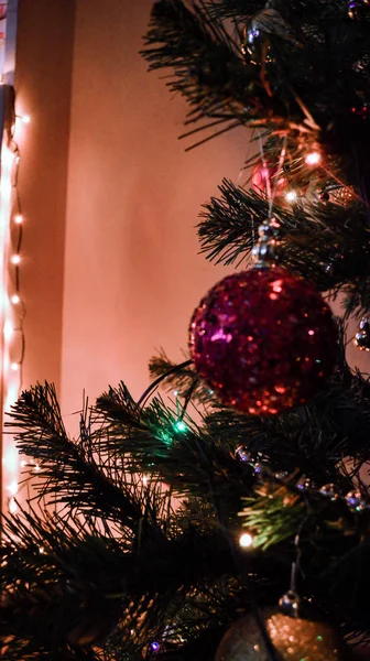 Speelgoed op kerstboom met fel licht — Stockfoto