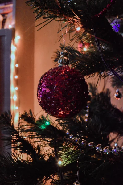 Leksaker på julgran med starkt ljus — Stockfoto