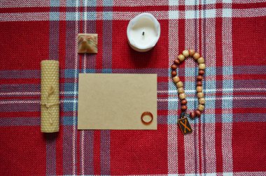 Ayin için esrarengiz ve sihirli şeyler. Mum, el işi çarşaf, dua boncukları, carnelian yüzüğü ve koyu kırmızı bez.