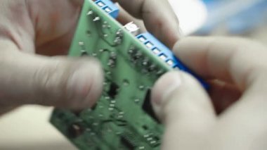 Bir işçi bir elektronik pano oluşturmaya çalışıyor. Yakın plan..