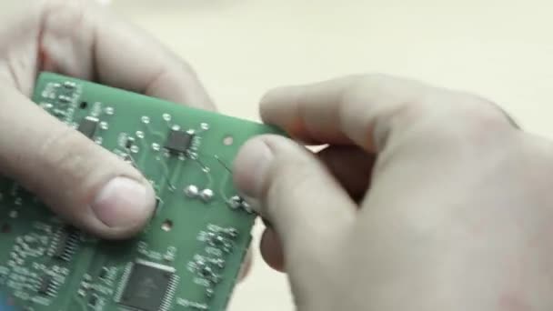 Een werknemer werkt aan de oprichting van een elektronisch bord. Close-up. — Stockvideo