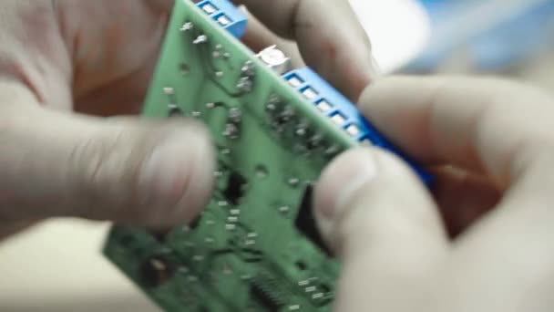 Een werknemer werkt aan de oprichting van een elektronisch bord. Close-up. — Stockvideo
