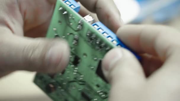 Ein Arbeiter arbeitet an der Erstellung einer elektronischen Tafel. Nahaufnahme. — Stockvideo