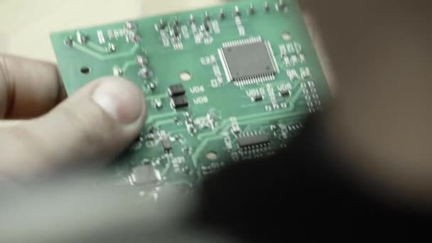Egy munkás dolgozik egy elektronikus tábla létrehozásán. Közelkép. — Stock videók