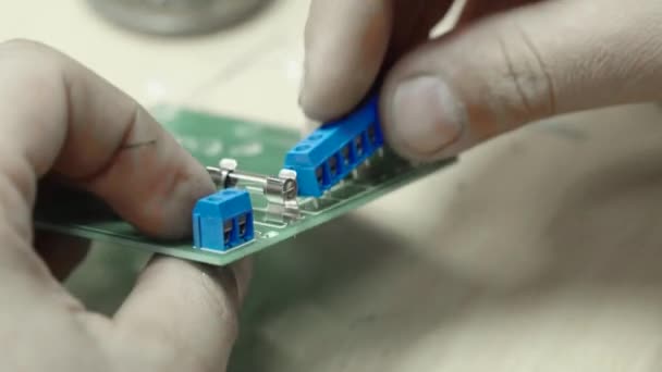 Un trabajador está trabajando en la creación de una tarjeta electrónica. Primer plano . — Vídeo de stock