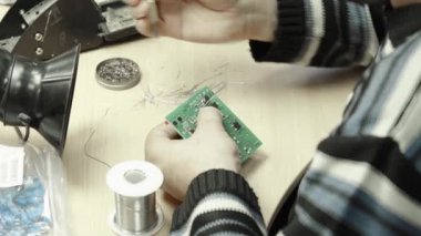 Bir işçi bir elektronik pano oluşturmaya çalışıyor. Yakın plan..
