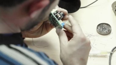 Bir işçi bir elektronik pano oluşturmaya çalışıyor. Yakın plan..