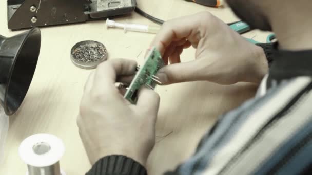 Een werknemer werkt aan de oprichting van een elektronisch bord. Close-up. — Stockvideo