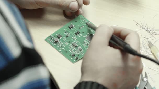 Een werknemer werkt aan de oprichting van een elektronisch bord. Close-up. — Stockvideo