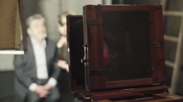 Ambrotype: Een fotograaf maakt een foto op een vintage camera in een studio. — Stockvideo