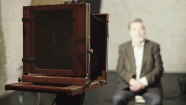 Ambrotype: Egy fotós egy régi fényképezőgépen készít képet egy stúdióban. — Stock videók