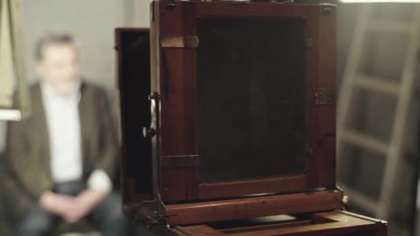 Ambrotype: Um fotógrafo tira uma foto em uma câmera vintage em um estúdio . — Vídeo de Stock
