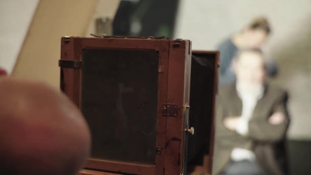 Ambrotype: Een fotograaf maakt een foto op een vintage camera in een studio. — Stockvideo