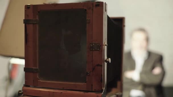 Ambrotype: Een fotograaf maakt een foto op een vintage camera in een studio. — Stockvideo