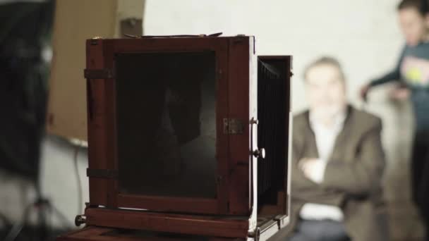 Ambrotyp: ein Fotograf macht ein Foto mit einer Vintage-Kamera in einem Studio. — Stockvideo