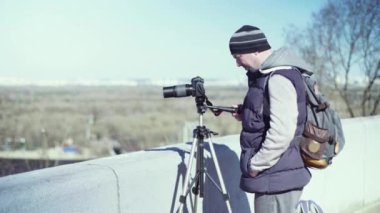 Kameraman fotoğrafçı, elinde kamera DSR 'ıyla şehirde bir tripoda video çekiyor. Kyiv. Ukrayna