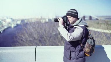 Kameraman fotoğrafçı, elinde kamera DSR 'ıyla şehirde bir tripoda video çekiyor. Kyiv. Ukrayna