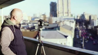 Kameraman fotoğrafçı, elinde kamera DSR 'ıyla şehirde bir tripoda video çekiyor. Kyiv. Ukrayna