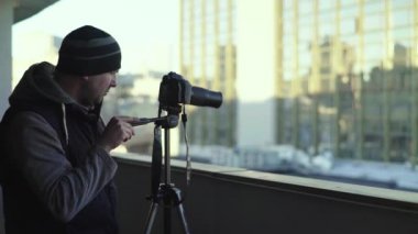 Kameraman fotoğrafçı, elinde kamera DSR 'ıyla şehirde bir tripoda video çekiyor. Kyiv. Ukrayna