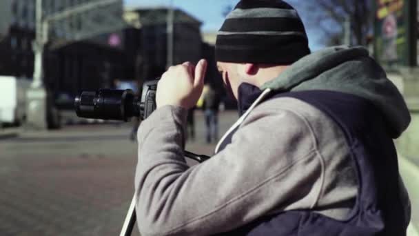 도시의 삼각대 위에 카메라 DSLR 카메라를 가진 카메라맨 사진사는 비디오 사진을 촬영한다. Kyiv. 우크라 이나 — 비디오