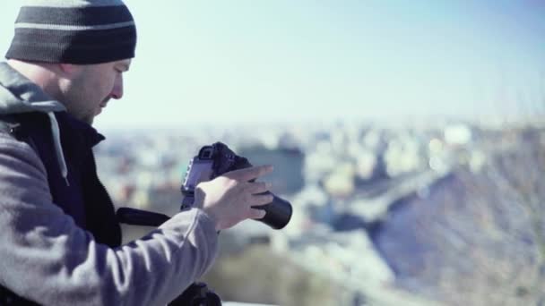 Fotografo cameraman con una fotocamera DSLR su un treppiede in città scatta foto video. Kiev. Ucraina — Video Stock