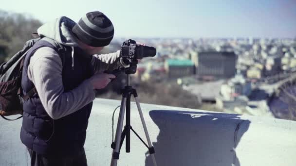 Fotografo cameraman con una fotocamera DSLR su un treppiede in città scatta foto video. Kiev. Ucraina — Video Stock