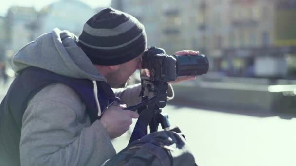 Cameraman photographer with a camera DSLR on a tripod in the city shoots video photo. Kyiv. Ukraine — Stock Video