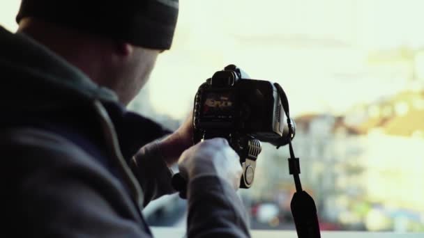 Fotograf cameraman cu o cameră DSLR pe un trepied în oraș fotografiază video. Kiev. Ucraina — Videoclip de stoc