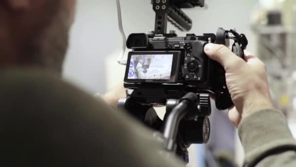 Gros plan d'un appareil photo reflex numérique dans les mains d'un photographe caméraman lors de la prise de vue d'une photo vidéo — Video