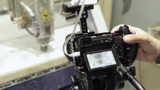 Gros plan d'un appareil photo reflex numérique dans les mains d'un photographe caméraman lors de la prise de vue d'une photo vidéo — Video