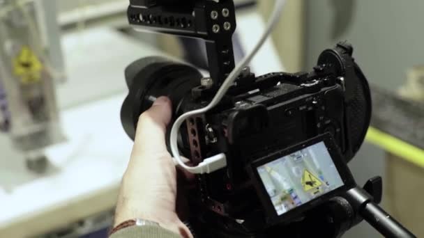 Close-up de uma câmera DSLR nas mãos de um fotógrafo de câmera enquanto fotografa uma foto de vídeo — Vídeo de Stock