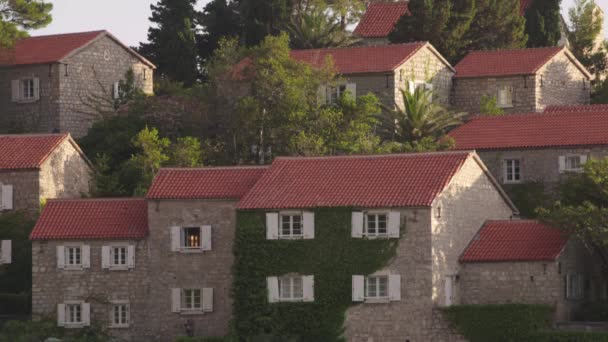 Piros cseréptetős házak. Sveti Stefan építészete. Montenegró. — Stock videók