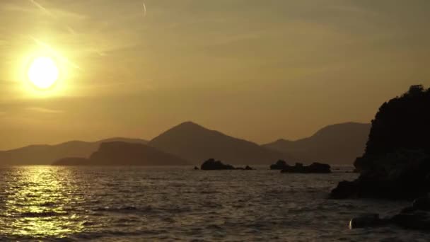 Ввечері на заході сонця накриває морська миша. Гори і море. Чорногорія — стокове відео
