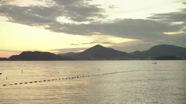 Zeegezicht in de avond bij zonsondergang. Bergen en de zee. Montenegro — Stockvideo