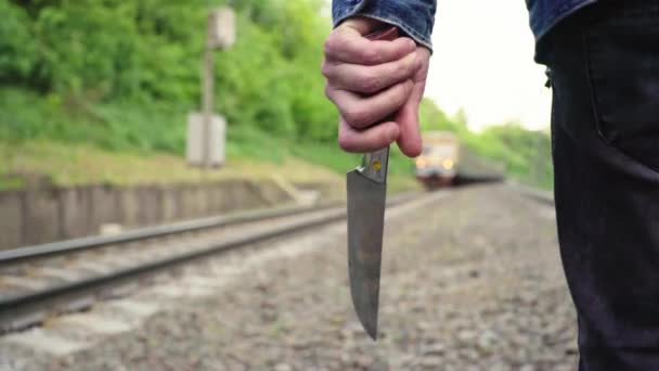 Маньяк с ножом возле железнодорожных путей . — стоковое видео