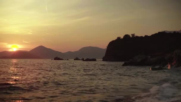 Przylądek morski wieczorem o zachodzie słońca. Góry i morze. Czarnogóra — Wideo stockowe