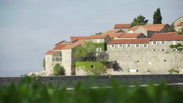 Piros cseréptetős házak. Sveti Stefan építészete. Montenegró. — Stock videók