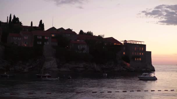 Sveti Stefan turistaváros a tenger mellett. Montenegró. Jó estét. — Stock videók