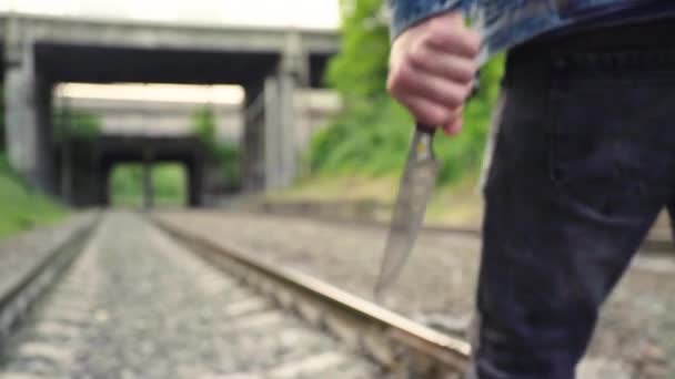 Wahnsinniger mit Messer in der Nähe der Bahngleise. — Stockvideo